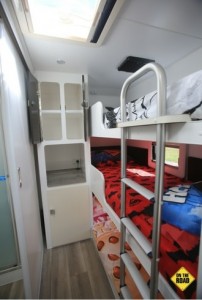 Triple bunks on the passenger side have a ladder for access to the top bunk and each bed has its own window and drop-down DVD player.